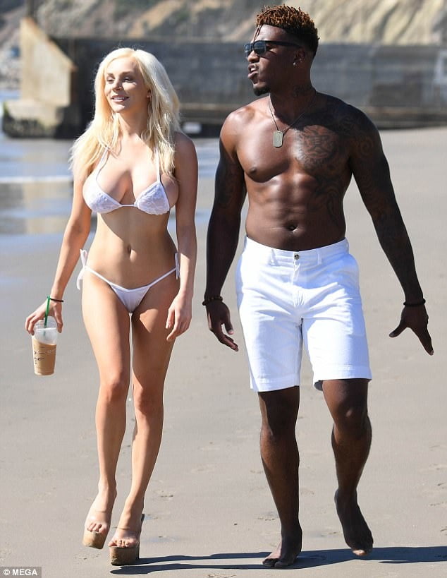 Donna in vacanza con uomini neri sulla spiaggia.
 #105251295