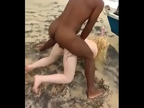 Frau im Urlaub mit schwarzen Männern am Strand.
 #105251300