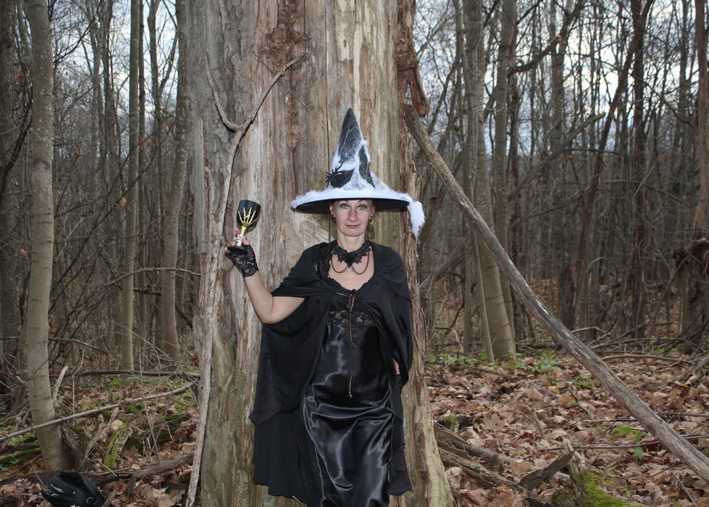 Witch with broom in wooded space