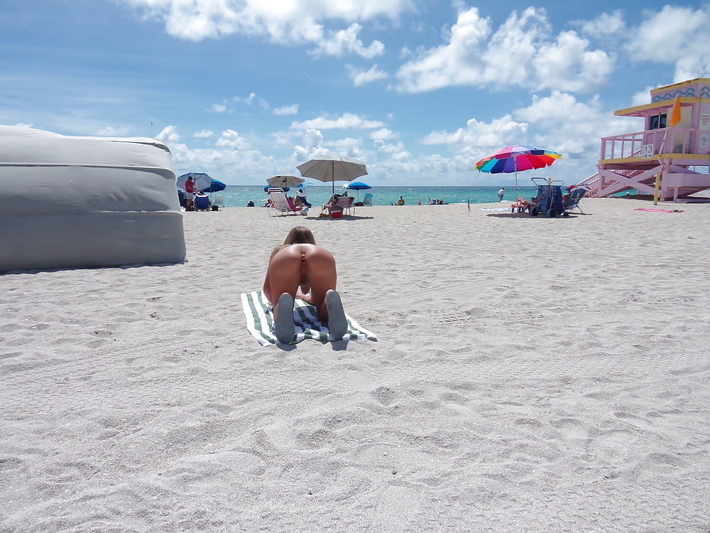 Salope américaine nue de la plage se penchant et écartant les jambes
 #98383274