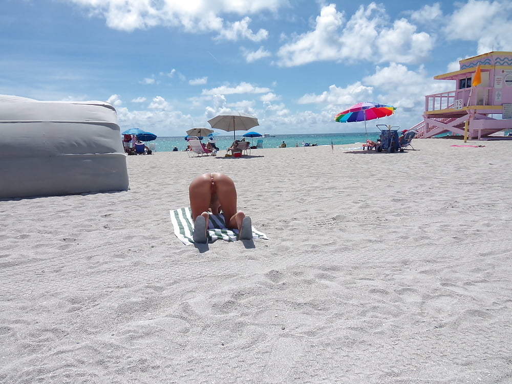 Salope américaine nue de la plage se penchant et écartant les jambes
 #98383276
