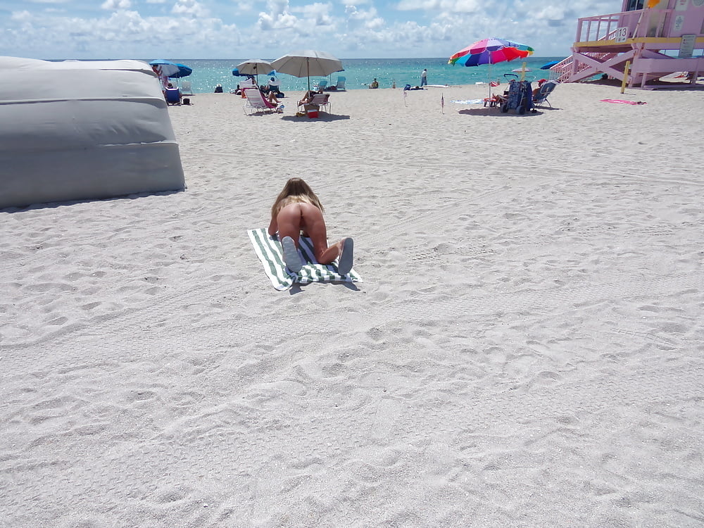 Salope américaine nue de la plage se penchant et écartant les jambes
 #98383277