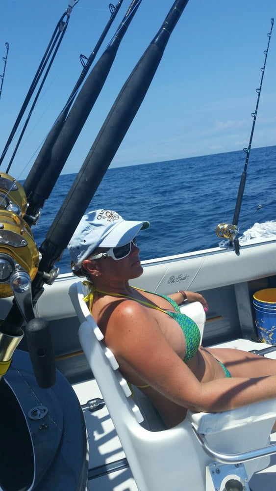ボートで釣りをしているホットなビキニ姿の女性
 #99094553