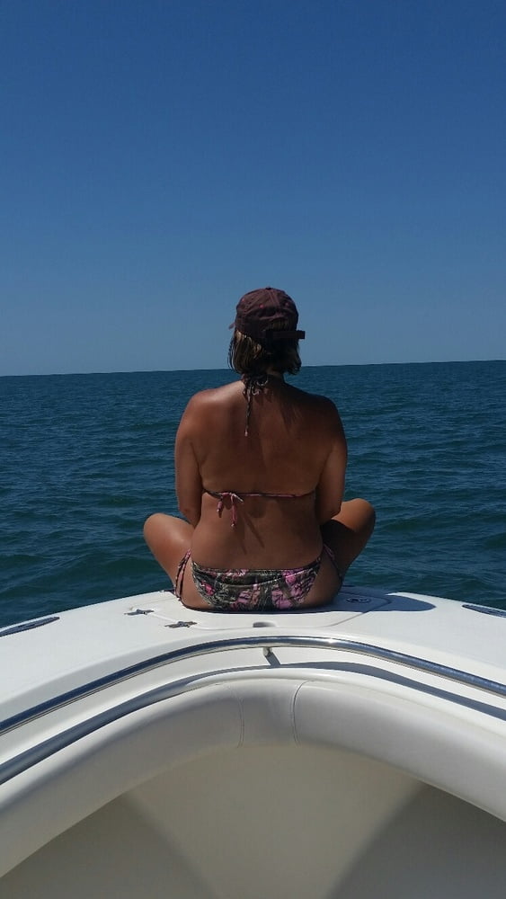 ボートで釣りをしているホットなビキニ姿の女性
 #99094555