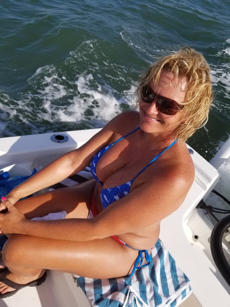 ボートで釣りをしているホットなビキニ姿の女性
 #99094575