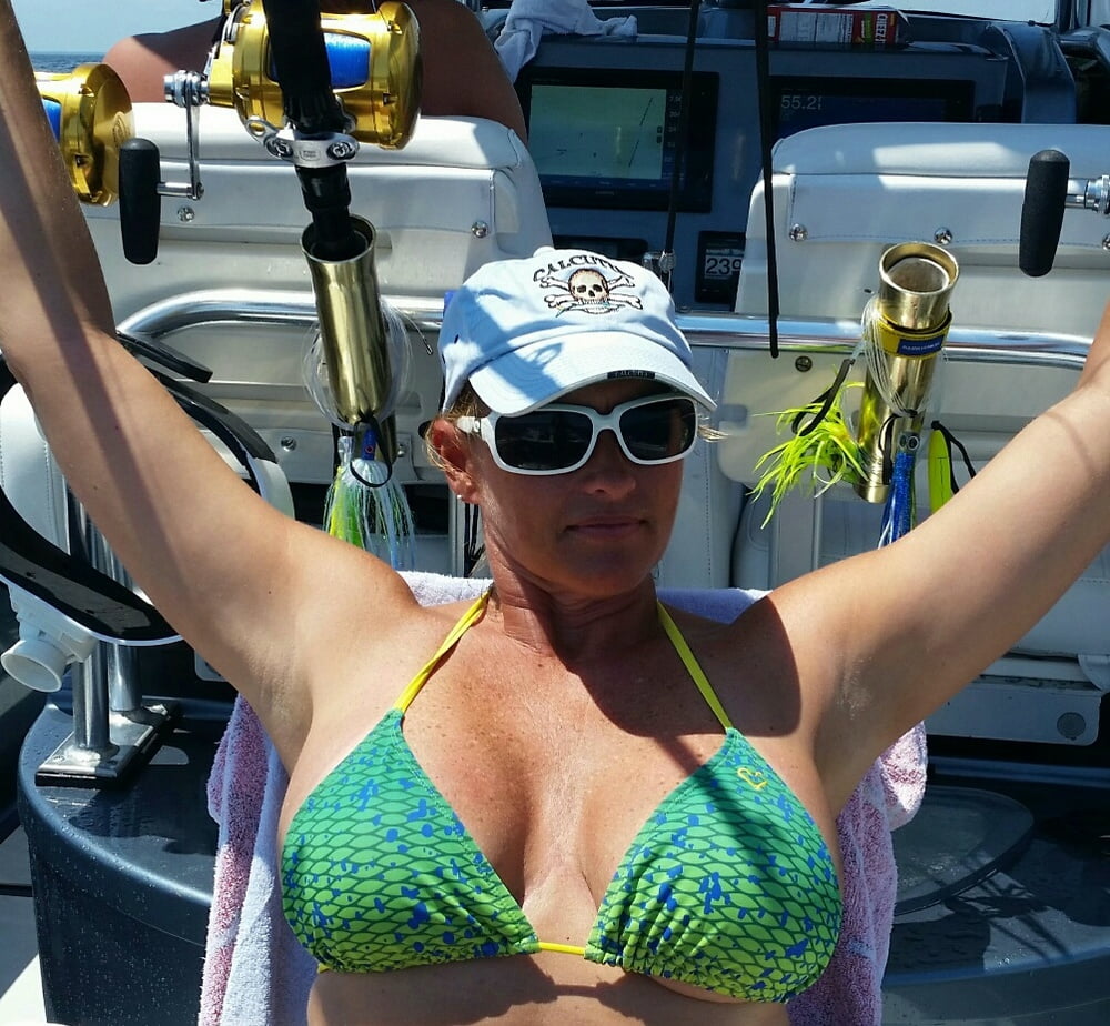 ボートで釣りをしているホットなビキニ姿の女性
 #99094601
