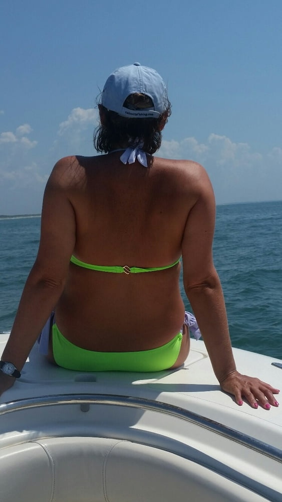 ボートで釣りをしているホットなビキニ姿の女性
 #99094633