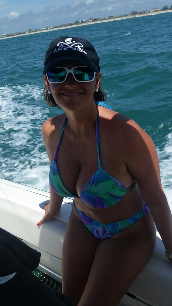 ボートで釣りをしているホットなビキニ姿の女性
 #99094658