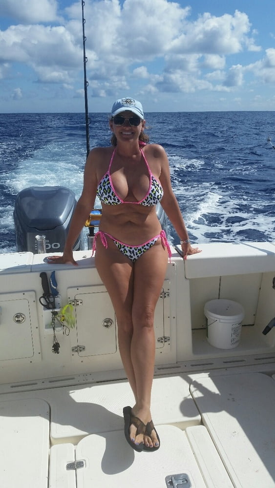 ボートで釣りをしているホットなビキニ姿の女性
 #99094671