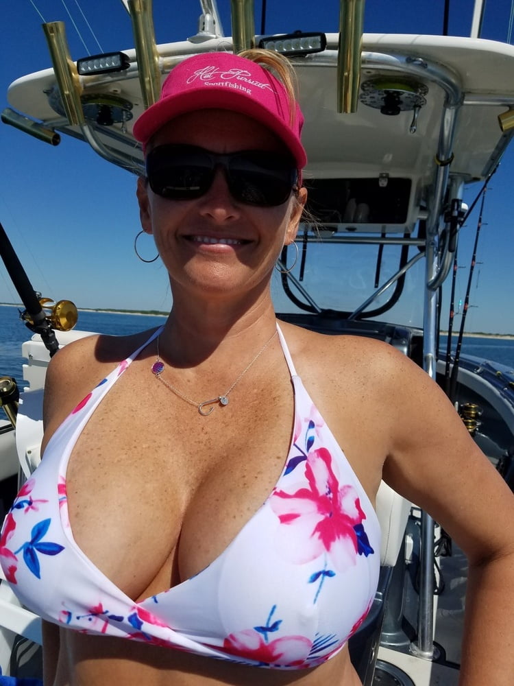 ボートで釣りをしているホットなビキニ姿の女性
 #99094688