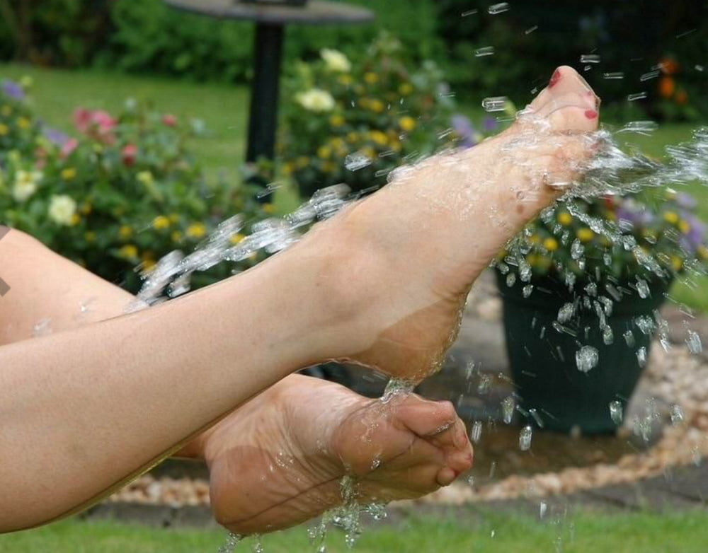 Sue befeuchtet ihren Slip im Garten
 #103667417