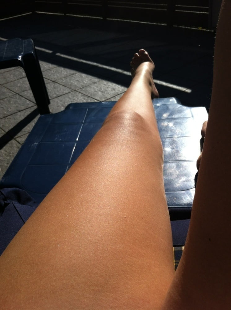 Beine und Füße in der Sonne auf dem Liegestuhl
 #97389993